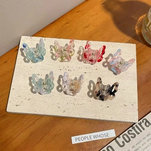 Close-up of seven colorful butterfly mini hair clips with elegant acetate textures