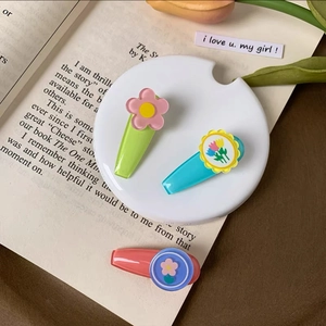 Detailed view of three cute pastel floral hair clips on a decorative white plate