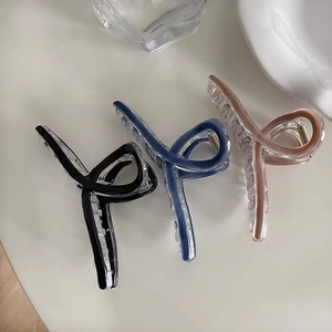 Three minimalist hair claw clips in black, mist blue, and nude pink with a matte finish