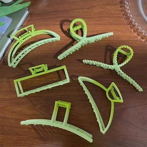 6-piece set of light green matte hair claw clips in various shapes on wooden background