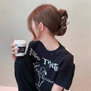 Lifestyle view of a silver irregular geometric metal hair claw clip for bun styling