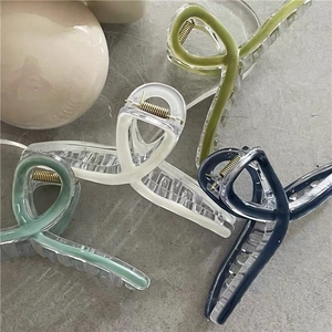 Close-up of four colorful crisscross hair claw clips in matte pastel shades for women