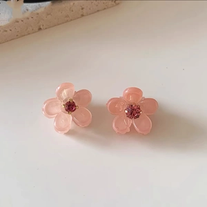 Dettaglio di fermagli per capelli a fiore rosa con centro in strass magenta brillante