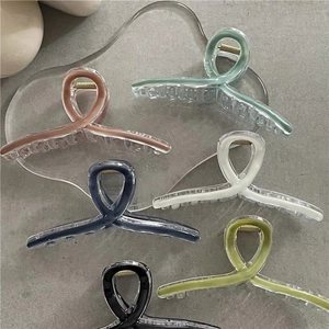 Flat lay of colorful acrylic shark hair clips in six vibrant summer shades on a tray