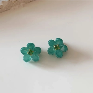 Dettaglio di piccole mollette a fiore turchese con cristallo per acconciature donna