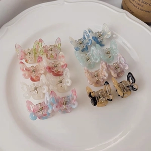 Set of 12 small butterfly hair clips with marble texture on a white ceramic plate