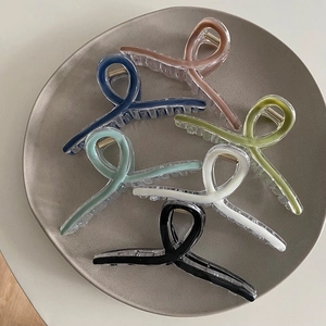 Detailed close-up of six matte shark hair claws in assorted pastel colors for summer styling