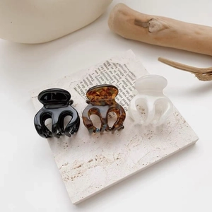Detailed view of small hair claws in black, tortoiseshell, and creamy white finishes