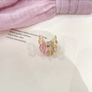 Detail view of a pink and green gradient butterfly hair claw clip with acrylic texture