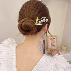 Épingle à cheveux élégante muguet stylisée dans un chignon classique et moderne chic