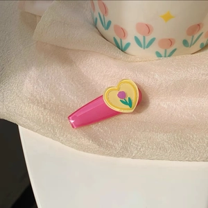 Close-up of a sweet tulip and heart hair clip on a soft textured fabric background