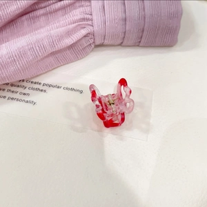 Detail of a small gradient pink butterfly hair claw clip with a marble texture finish