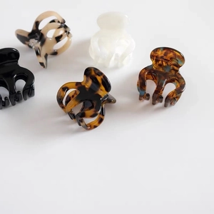 Detailed close-up of octopus claw hair clips in various tortoise shell and marble resin patterns