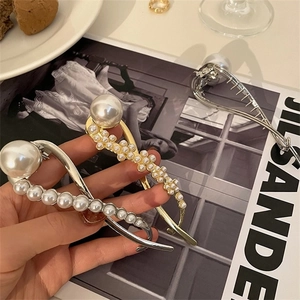 Detail van elegante parelhaarclips in goud en zilveren afwerking met Frans ontwerp