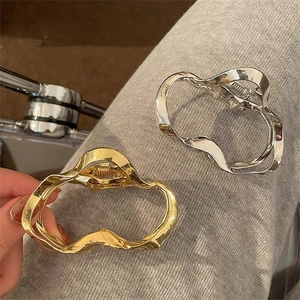 Irregular geometric wavy metal hair claw clips in polished gold and silver finishes