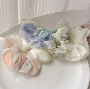 Close-up of four assorted organza scrunchies in pastel plaid and white textures