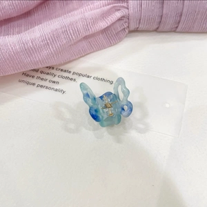 Close-up of butterfly hair claw clip with blue and white marble texture resin