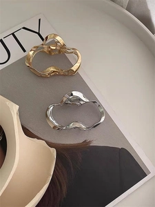 Macro detail of irregular geometric metal hair clips in gold and silver finish