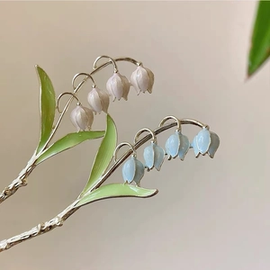 Détail d'épingles à cheveux muguet avec pétales émaillés et branches en métal argenté