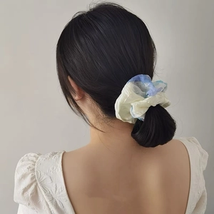 Macro view of blue and yellow watercolor dye mesh scrunchie on a ponytail