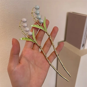 Détail de l'épingle à cheveux muguet rose et bleue avec finition en métal doré