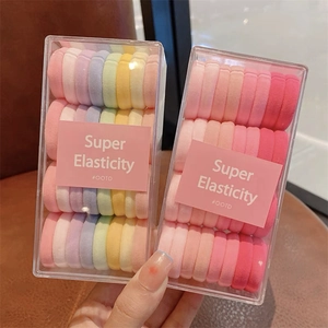 Gros plan sur des élastiques à cheveux super extensibles en boîtes, tons macaron et rose