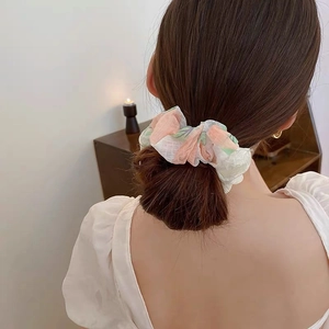 Detailed back view of pink and green floral mesh scrunchie worn on a high ponytail