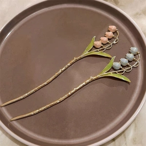 Détail d'épingles à cheveux muguet rose et bleu avec métal doré et décor en émail fin