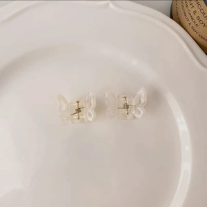 Detail of pearlescent white butterfly hair claw clips with gold metal spring mechanism