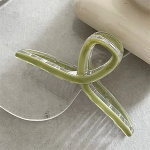 Macro view of a large translucent olive green hair claw clip with a glossy jelly texture