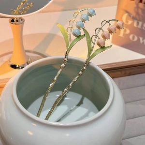 Détail d'épingles à cheveux muguet élégantes en émail bleu et rose pastel