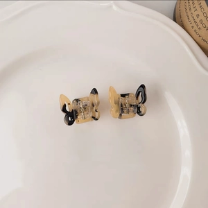 Detailed macro view of two mini butterfly hair clips with retro amber pattern