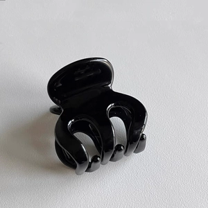 Close-up of a glossy black octopus hair claw clip for high ponytail stability