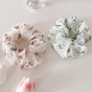 Détail de chouchous floraux en tissu quadrillé transparent aux motifs rose et vert