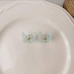 Close-up of a pair of butterfly hair clips in light blue translucent matte resin