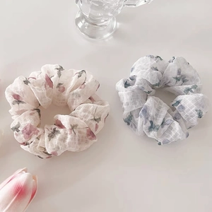 Détail de chouchous à fleurs en tissu rose et bleu avec une texture à carreaux subtile
