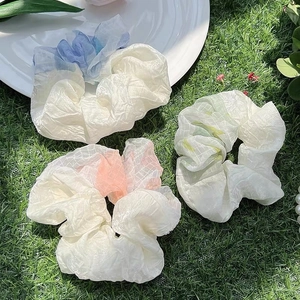Close-up of translucent mesh fabric scrunchies in pastel blue pink and green tones