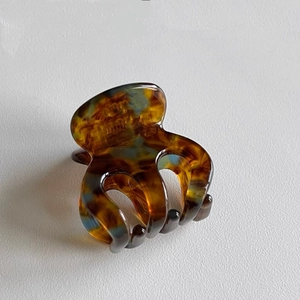 Close-up of tortoise shell resin claw clip with curved teeth for high ponytails