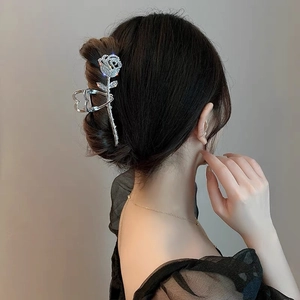 Detail of silver rose hair claw with sparkling rhinestones worn on black hair
