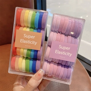 Gros plan d'élastiques à cheveux arc-en-ciel super extensibles en boîtes transparentes