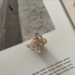 Macro detail of a small butterfly hair claw with purple marble texture on a magazine page