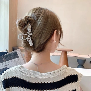 Silver metal tulip hair claw clip holding a bun hairstyle on model's back view