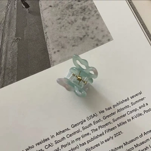 Detail view of small butterfly hair claw clip in mint green gradient resin finish