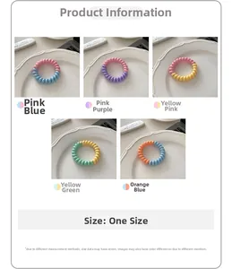 Gros plan d'élastiques à cheveux spirale pastel sur une assiette en céramique blanche