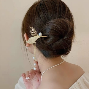 Golden mermaid tail hair pin with white pearls and long tassel on elegant updo