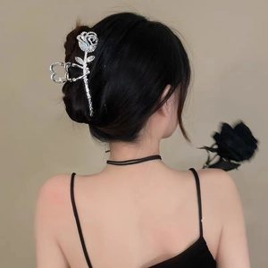 Detailed view of a silver rose hair claw clip with rhinestones worn on an elegant updo