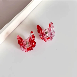 Detail of small butterfly hair clips with red and pink gradient resin wings