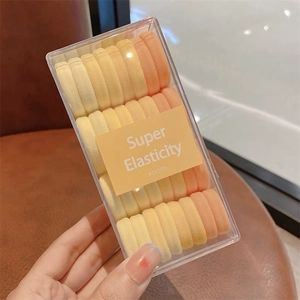 Gros plan d'élastiques à cheveux haute élasticité orange dégradé avec boîte de rangement