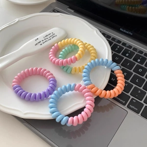 Set d'élastiques à cheveux spirale colorés aux tons pastels sur plateau blanc