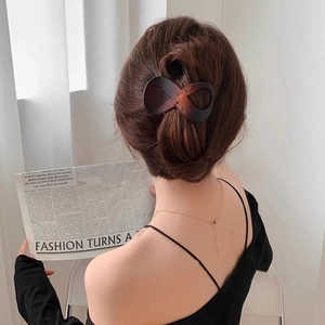 Detail view of dark tortoise shell infinity hair claw clip in a stylish updo hairstyle